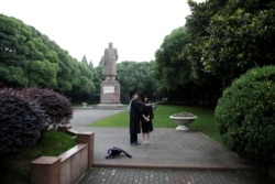 Students take pictures in front of the statue of Chinese leader Mao Zedong after their graduation ceremony at Fudan University in Shanghai, China on June 23, 2017.