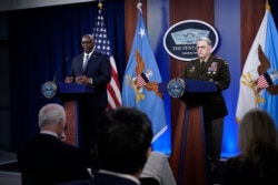 Secretary of Defense Lloyd Austin, left, answers a question during a briefing with Joint Chiefs Chairman Gen. Mark Milley at the Pentagon in Washington, Sept. 1, 2021, about the end of the war in Afghanistan.