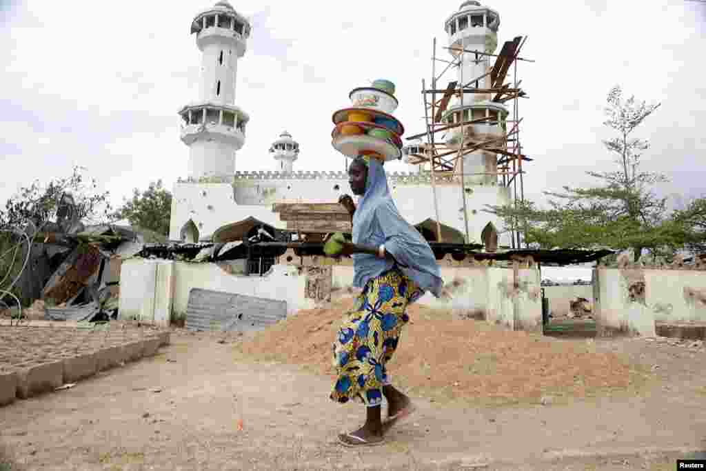 A girl walks past a destroyed mosque in the town of Mararaba, after the Nigerian military recaptured it from Boko Haram, in Adamawa state, May 10, 2015.