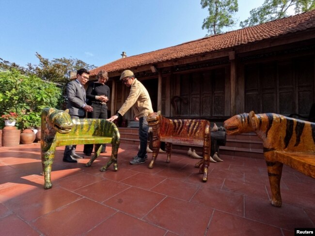 Nguyen Tan Phat shows his Tiger carving works to the customers ahead of the New Lunar New year in Hanoi, Vietnam January 18, 2022. (REUTERS/Stringer)