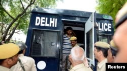 Seorang pria dikawal ketat saat akan keluar dari mobil polisi menuju pengadilan di New Delhi (Foto: dok).