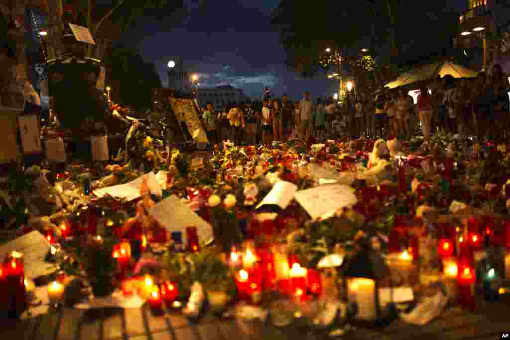 گردهمایی گروهی از مردم مقابل شمع ها و دسته های گل به یاد قربانیان حمله تروریستی در بارسلون اسپانیا