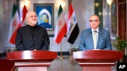 Menteri Luar Negeri Iran, Mohammad Javad Zarif (kiri) dan Menlu Irak Mohammed Alhakim, melakukan konferensi pers bersama di Baghdad, hari Minggu (26/5). 