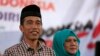 FILE - Indonesian presidential candidate Joko "Jokowi" Widodo (L) looks on as he sits with his wife Iriana during a campaign rally in Majalengka, West Java province.