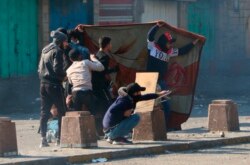 Para pemrotes anti-pemerintah berlindung selama bentrokan dengan pasukan keamanan di Baghdad, Irak, Jumat, 31 Januari 2020. (AP Photo / Hadi Mizban)
