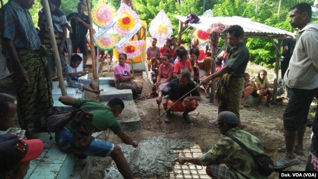 Warga merapikan makan Adelina setelah jenazah dikebumikan pada Senin, 19 Februari 2018 lalu (foto: dok VOA)