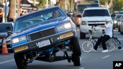 Foto de archivo. Un 'lowrider' viaja sobre tres ruedas en Sunset Blvd., en el vecindario Echo Park de Los Ángeles. (Foto AP/Damian Dovarganes)