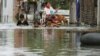 Residents travel on a flooded street in Phnom Penh September 26, 2011.The death toll from flooding in Thailand since mid-July has risen to 158, while 61 people have died in neighbouring Cambodia in the past two weeks, authorities in the two countries said