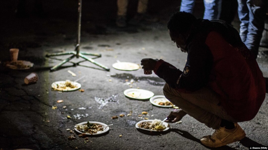 Para migran dan pengungsi makan malam di jalan bawah tanah di Ventimiglia, Italia, menunggu malam untuk menyebarangi Perancis, Desember 2017.