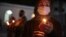 A believer wearing a protective mask holds a candle outside a church during an Orthodox Easter service, amid the coronavirus disease outbreak, in Marneuli, Georgia, April 18, 2020. 