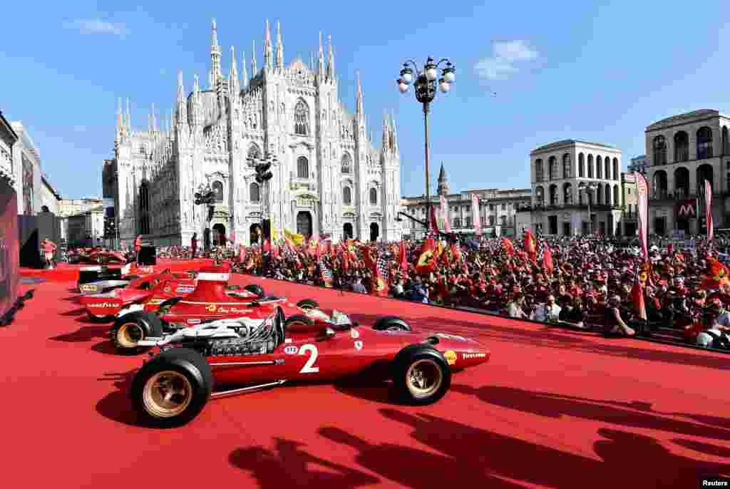 People attend an event to celebrate 90 years of Italian premium sports car maker Ferrari racing team at Milan&#39;s Duomo square in Milan, Italy.