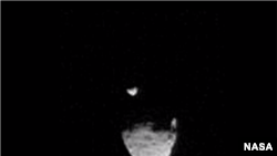 Gambar dari video yang diambil menunjukkan bulan Phobos melintas di depan bulan Deimos.