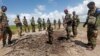 FILE - Somali soldiers stand at a Somali military base, near the site of an attack by al-Shabab, in Lower Juba, June 13, 2018. The base was the target of another al-Shabab assault Monday.