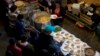 Breakfast of rice, beans and tortilla chips is prepared for Honduran migrants inside an empty warehouse that opened its doors to migrants in downtown Tijuana, Mexico, Dec. 18, 2018. The owner opened the warehouse, closed for years, so some migrants don't sleep outside.