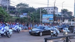 The hands of the Cameroonian First Lady Chantal Biya are seen greeting a crowd of supporters of the ruling Cameroon Paople's Democratic Movement (CPDM) as she travels with her husband, Cameroon President Paul Biya, upon their return to the country on Octo