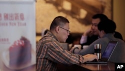 FILE - A man surfs the Internet on his laptop computer at a cafe in Beijing, China, Feb. 16, 2015.