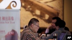 Seorang pria tampak menggunakan laptopnya di salah satu cafe di Beijing, China, pada 16 Februari 2015. (Foto: AP/Andy Wong)