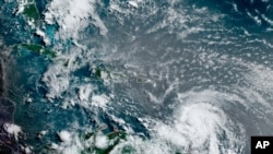 Cette image satellite fournie par la National Oceanic and Atmospheric Administration montre l'ouragan Elsa se déplaçant à travers les Caraïbes, au-dessus de la Barbade, le mardi 2 juillet 2021, à 12 h 00 (8 h HE). Elsa devait passer près de la côte sud…