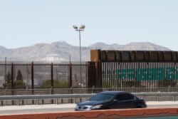 A car drives on a highway parallel to a border fence between the United States and Mexico in El Paso, Texas, April 22, 2020.