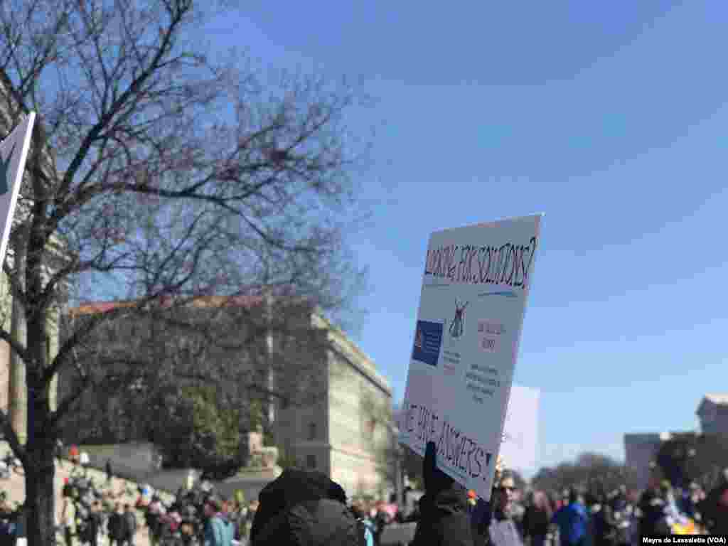 Um manifestante da Marcha Pelas Nossas Vidas exibe um cartaz que diz "Melhores Soluções"