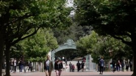 FILE - People walk in front of Sather Gate on the University of California at Berkeley campus in Berkeley, Calif., Thursday, July 18, 2019.