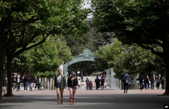 FILE - People walk in front of Sather Gate on the University of California at Berkeley campus in Berkeley, Calif., Thursday, July 18, 2019.