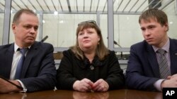 FILE - Oksana Sevastidi, with her lawyers, awaits a court hearing in the Russian Supreme court in Moscow, Russia, March 15, 2017. Sevastidi was convicted of treason for sending text messages about military movements near Georgia's breakaway republic of Abkhazia. Putin pardoned Savastidi that month, and pardoned two other women serving prison sentences for the same offense Saturday.