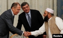 FILE - Russian Foreign Minister Sergei Lavrov welcomes member of Taliban delegation Alhaj Mohammad Sohail Shaina during the multilateral peace talks on Afghanistan in Moscow, Russia, Nov. 9, 2018.