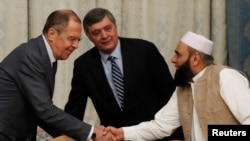 FILE - Russian Foreign Minister Sergei Lavrov welcomes member of Taliban delegation Alhaj Mohammad Sohail Shaina during earlier talks, Nov. 9, 2018. Russian officials have confirmed that there will be no participation by the Taliban government at the 2022 talks.