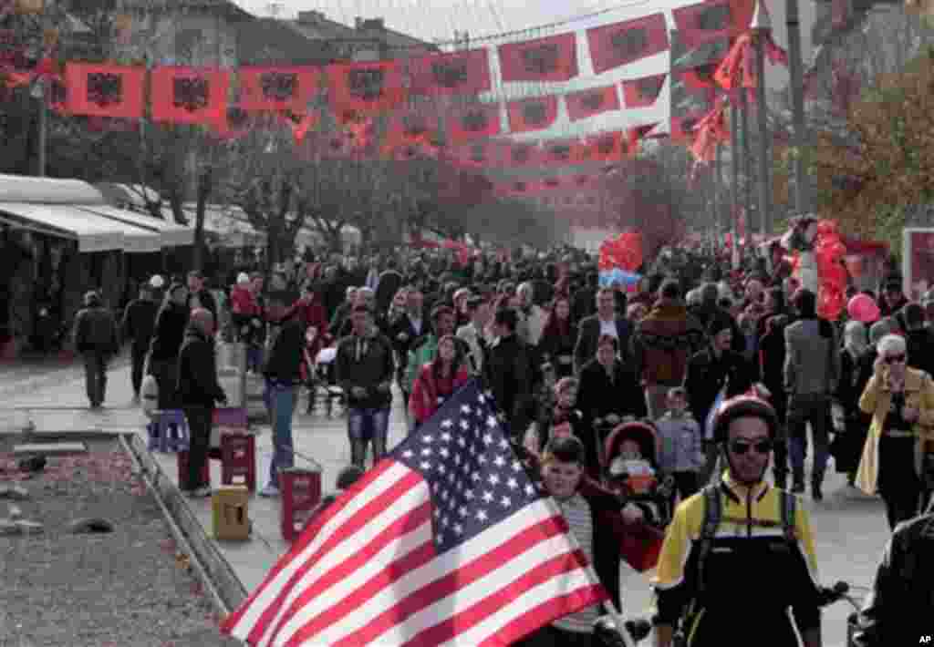 Kosovo Albanians walk in the main square decorated with Albanian flags in capital Pristina, Kosovo on Wednesday, Nov. 28, 2012. Albania is celebrating its 100th anniversary of independence with national flag blanketing city squares, apartment buildings 