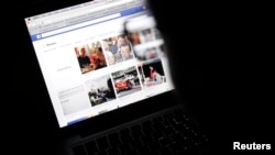 Vietnamese Internet activist Nguyen Lan Thang looks at a Facebook page at a cafe in Hanoi, Nov. 27, 2013. 