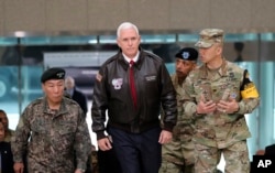 ຮອງປະທານາທິບໍດີ ສຫລ ທ່ານ Mike Pence ພວມຍ່າງ ທີ່ບ້ານຊາຍແດນ Panmunjom ໃນເຂດປອດທະຫານ ທີ່ແບ່ງເກົາຫຼີເໜືອ ແລະເກົາຫຼີໃຕ້ ອອກຈາກກັນ.