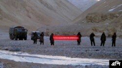 Beberapa tentara China di perbatasan membentangkan tulisan "You've crossed the border, please go back" dekat Ladakh, India (foto: dok). 