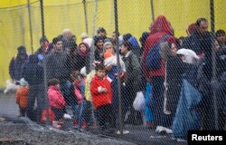 FILE - Migrants wait to cross the border from Slovenia into Spielfeld in Austria, Feb. 16, 2016.