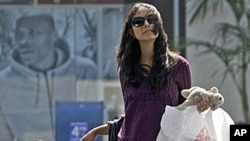A woman and child leave a mall with purchases in Culver City, Calif., (File).