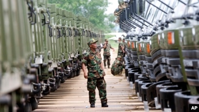 FILE PHOTO - A Cambodian army soldier looks at Chinese military vehicles displayed before a handover ceremony at a military airbase in Phnom Penh, Cambodia, Wednesday, June 23, 2010. 