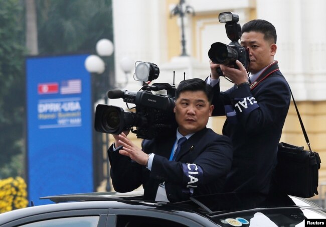 Members of North Korean media take images as the motorcade of North Korea's leader Kim Jong Un rides past the Opera House, after the second U.S.-North Korea summit in Hanoi, Vietnam, Feb. 28, 2019.