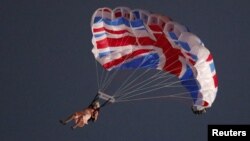 Penerjun payung Gary Connery melakukan terjun dari helikopter dengan parasut berhiaskan bendera Inggris. Connery mengenakan pakaian sama seperti pakaian Ratu Elizabeth lengkap dengan rambut 'wig' (27/7). 