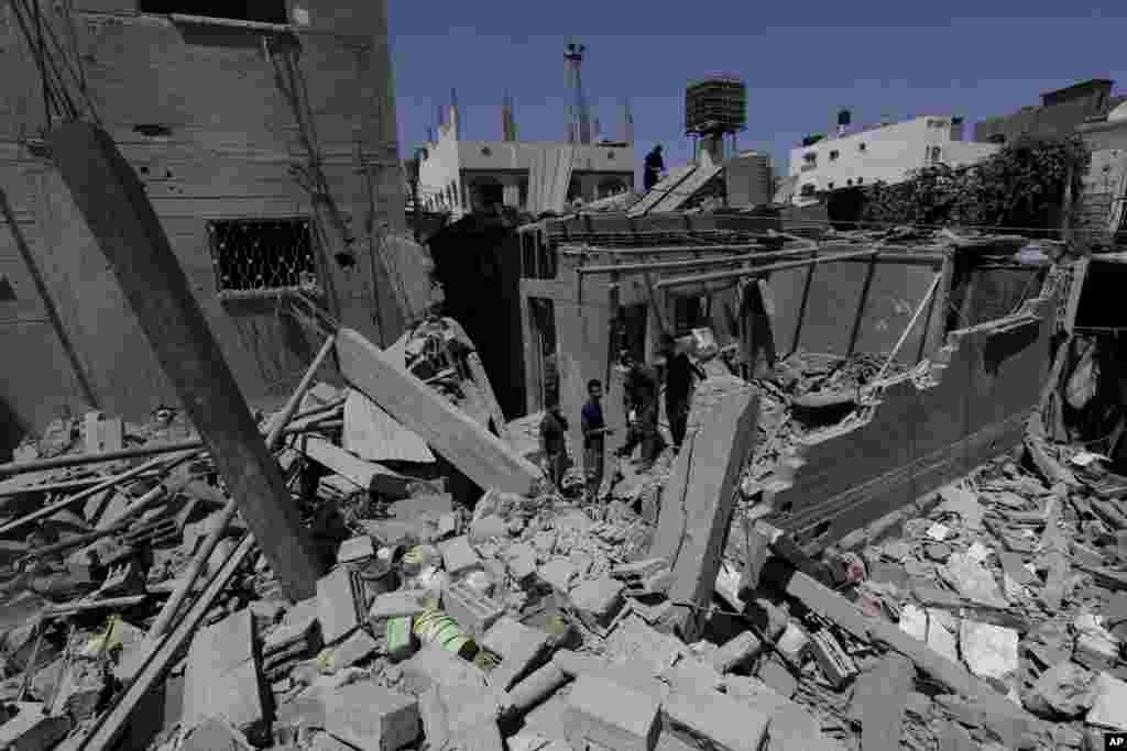 Palestinians, who are neighbors of a house belonging to Abu Hamada family, inspect the damage to their houses, after an Israeli strike in Jebaliya refugee camp, in the northern Gaza Strip, Monday, Aug. 25, 2014