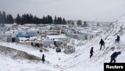 Pengungsi Suriah bermain salju di tengah badai salju di Kota Zahle, di Lembah Bekaa, 11 Desember 2013. (Foto:dok)