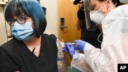 FILE - A nurse gives a volunteer an injection during a study of a COVID-19 vaccine developed by the National Institutes of Health and Moderna Inc., July 27, 2020, in Binghamton, N.Y. 