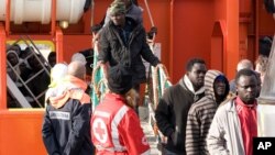 Migrants disembark from a tug boat after being rescued in the harbor of Lampedusa, Italy, Feb. 16, 2015. 