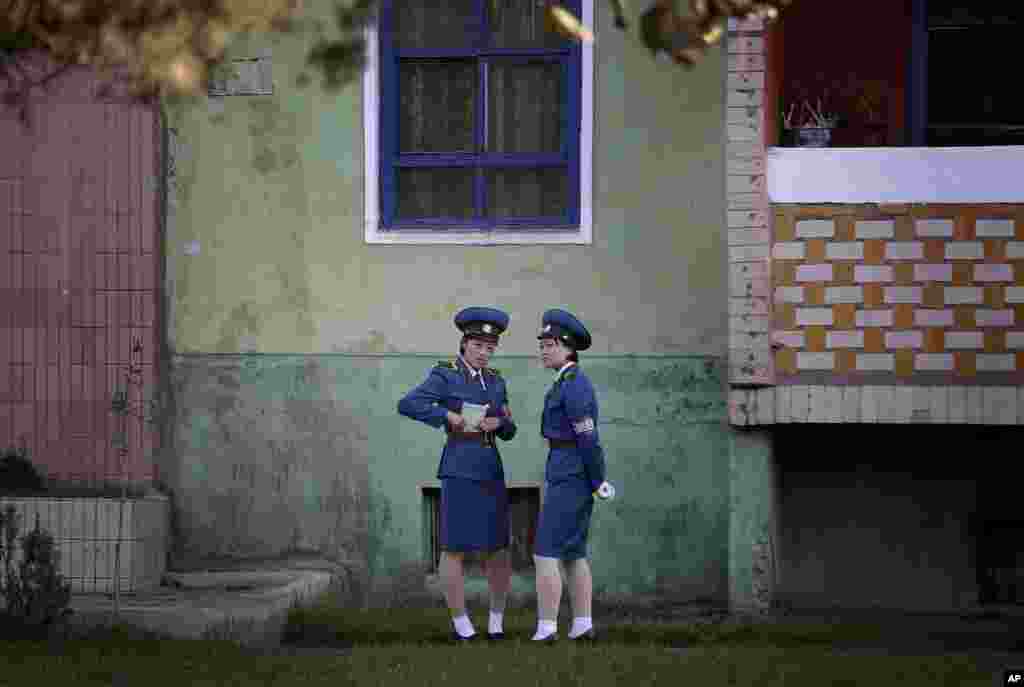 North Korean traffic police women chat next to a residential building while off duty in Pyongyang.