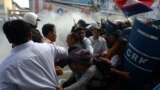 Mam Sonando (C), owner of the independent Beehive radio station and prominent government critic, and other activists, run as military police officers (R) disperse the crowd during a protest in Phnom Penh, Cambodia.