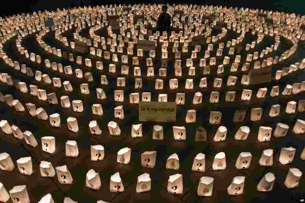 A Kosovo boy sits in the middle of a circle of lit candles to commemorate those who went missing during 1998-99 Kosovo war, in Pristina, Kosovo, Apr. 26, 2013.