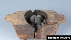 Wooden brazier and burned stones from an archaeological site in western China.