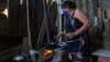 A woman cooks on a wood stove in the outskirts of São Paulo, Nov. 14, 2021. (Yan Boechat/VOA) 