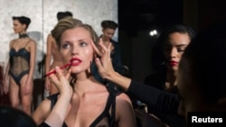 Make-up artists apply finishing touches to a model before a presentation of creations from the La Perla Autumn/Winter 2013 collection during New York Fashion Week in New York February 7, 2013.