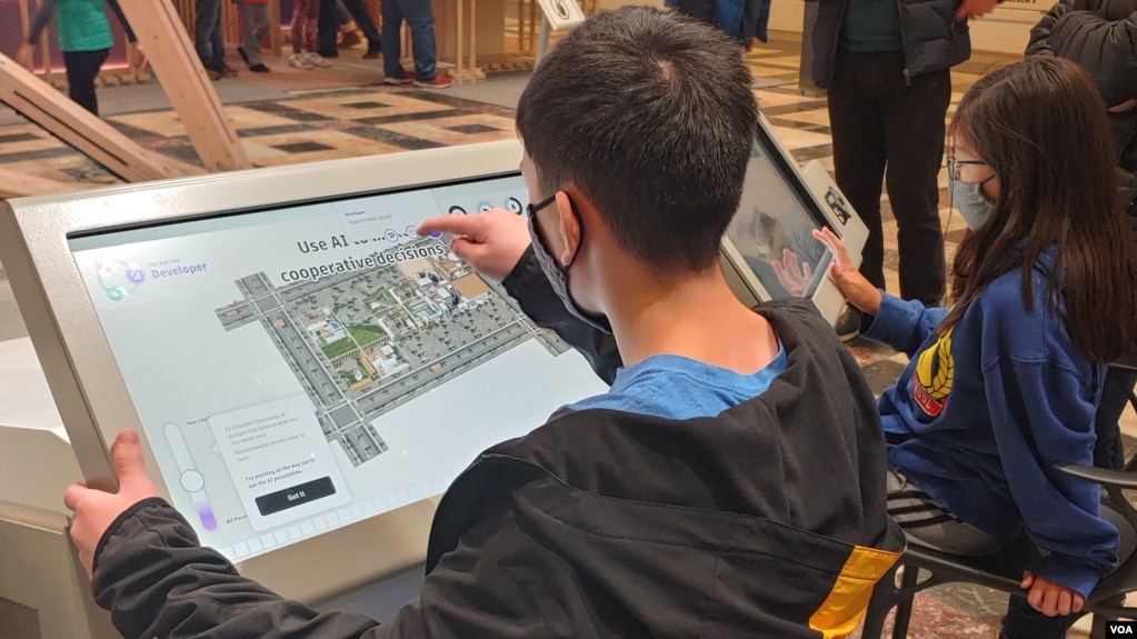 These children are working together to create their perfect town of the future with input from computer intelligence. (Deborah Block/VOA)