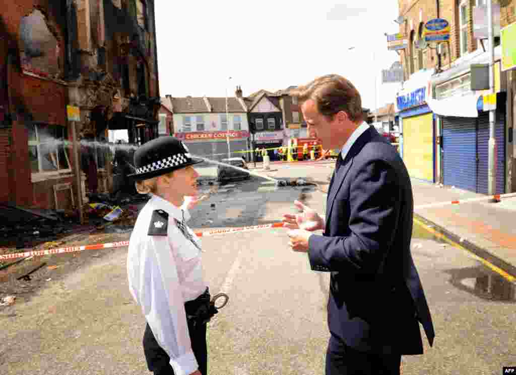 August 9: Britain's Prime Minister David Cameron speaks with acting borough commander, Superintendent Jo Oakley, in south London. REUTERS/Stefan Rousseau